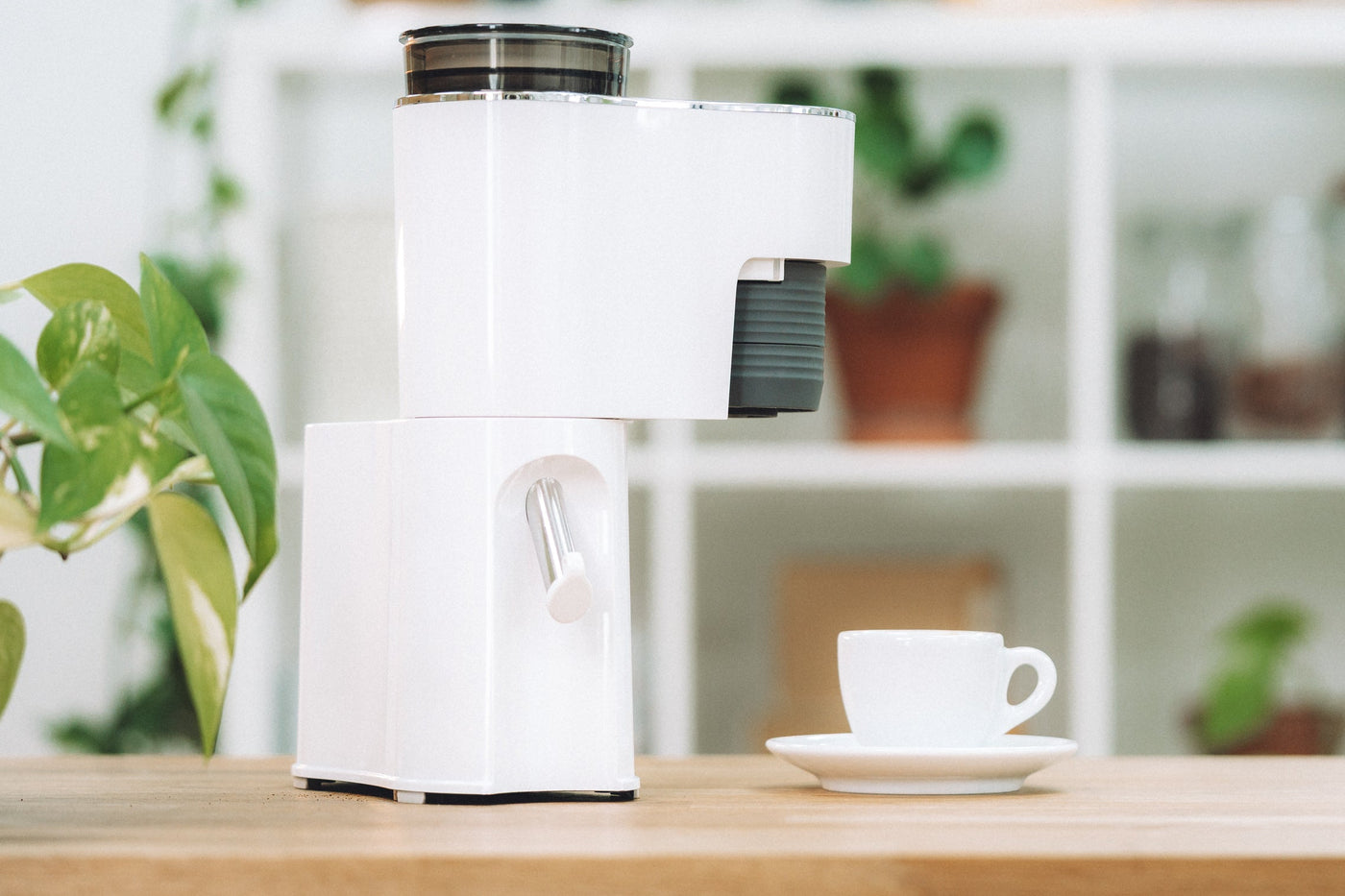 White coffee machine on a wooden table with a blurred background