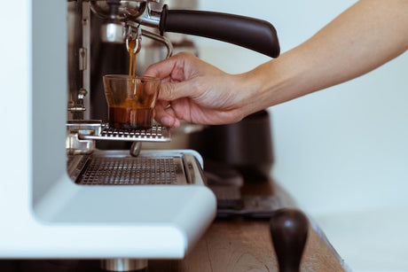 espresso pouring into glass from espresso machine